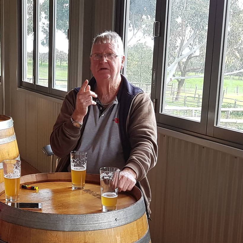 Paul at a barrel table with two glasses of beer